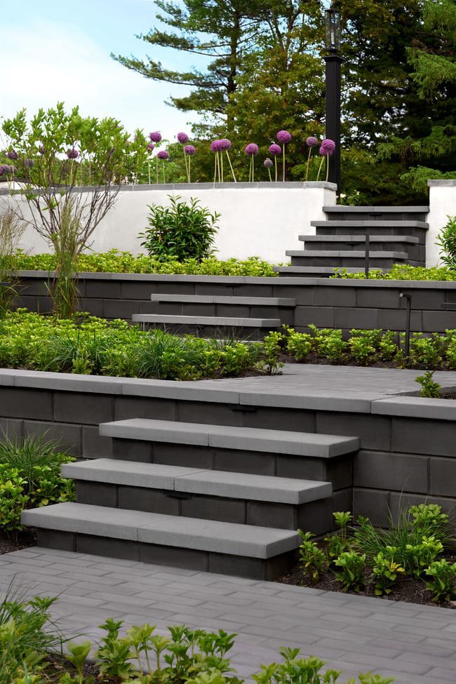 Walkways with stairs installed throughout garden beds in a backyard.