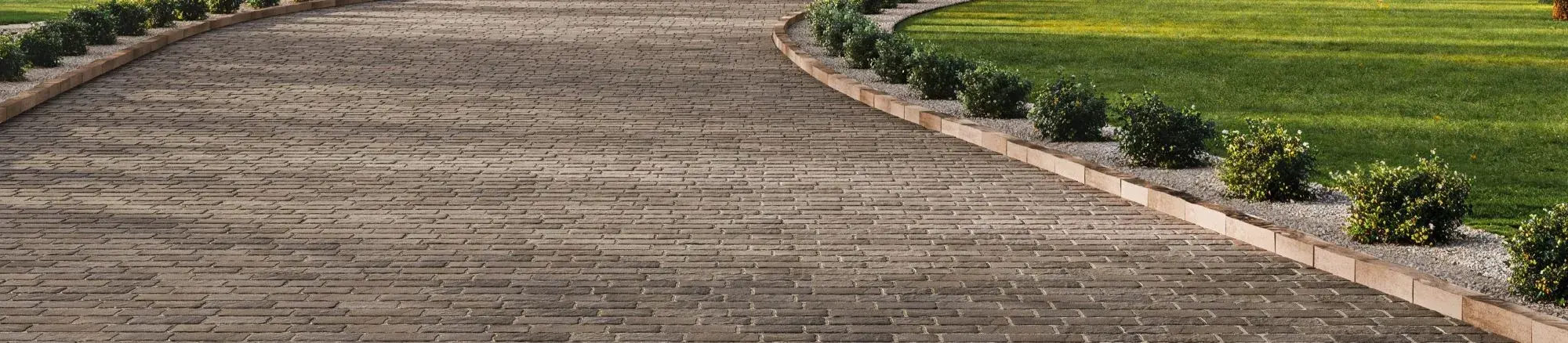 Saint-Oxford Paver by Techo-Bloc in Sepia Brown with slate texture, laid in a linear pattern for a timeless driveway design.