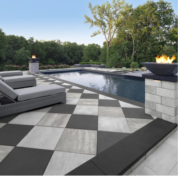 Modern backyard landscaping with Techo-Bloc paving stones, including a fire pit, deck, outdoor kitchen and walkway, displayed on a tablet for an interactive project cost estimate.
