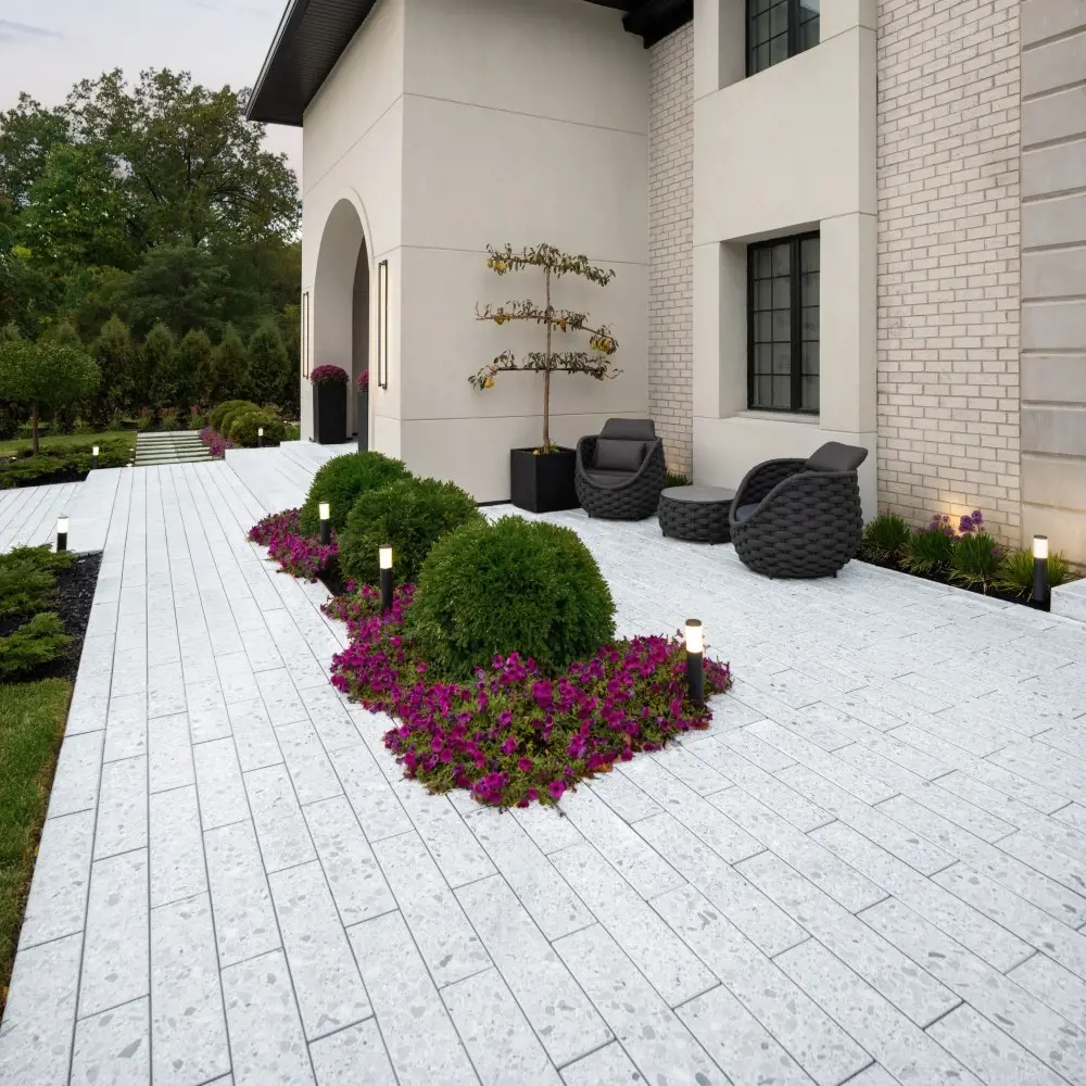 Garden walkway with Terrazzo 600x150 concrete slabs in Mineral White, framed by low planting beds and architectural seating areas.