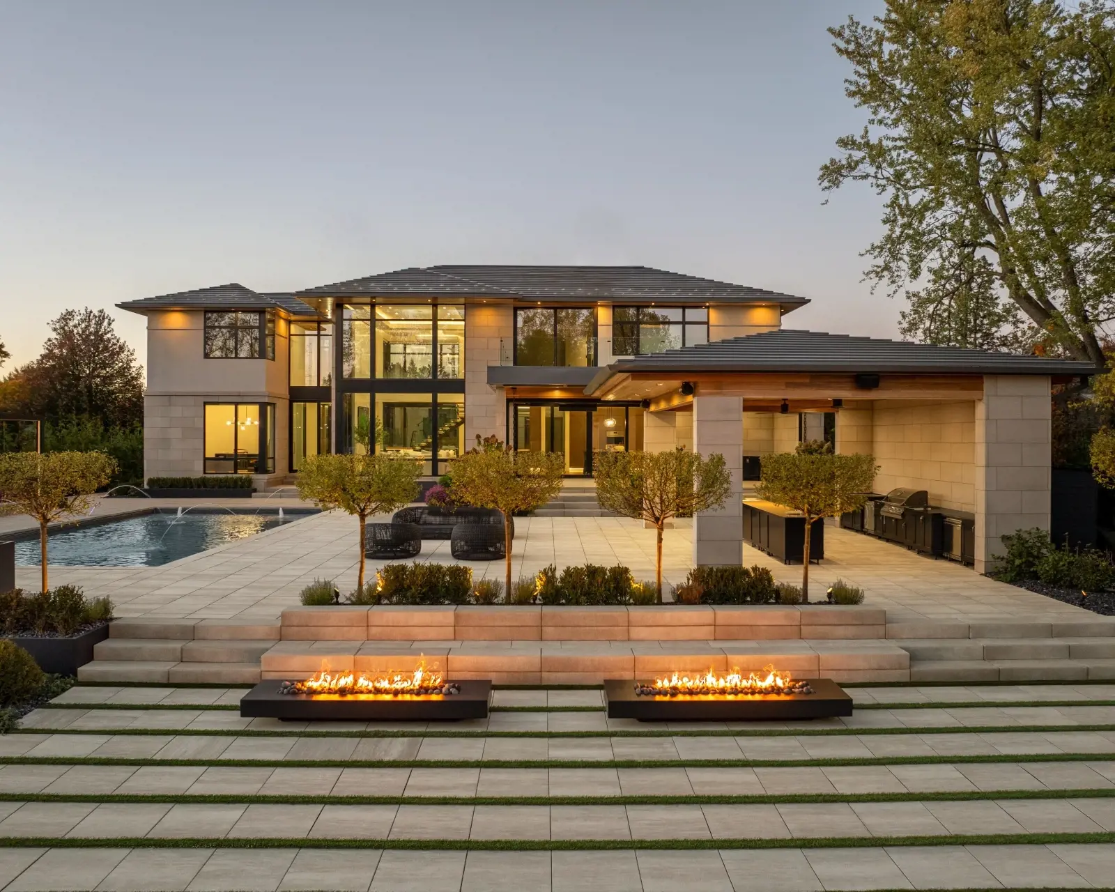 Contemporary residence with layered terraces and fire features, surfaced with Industria Smooth Slabs in Caffè Crema that bring warmth and softness to the modern design.