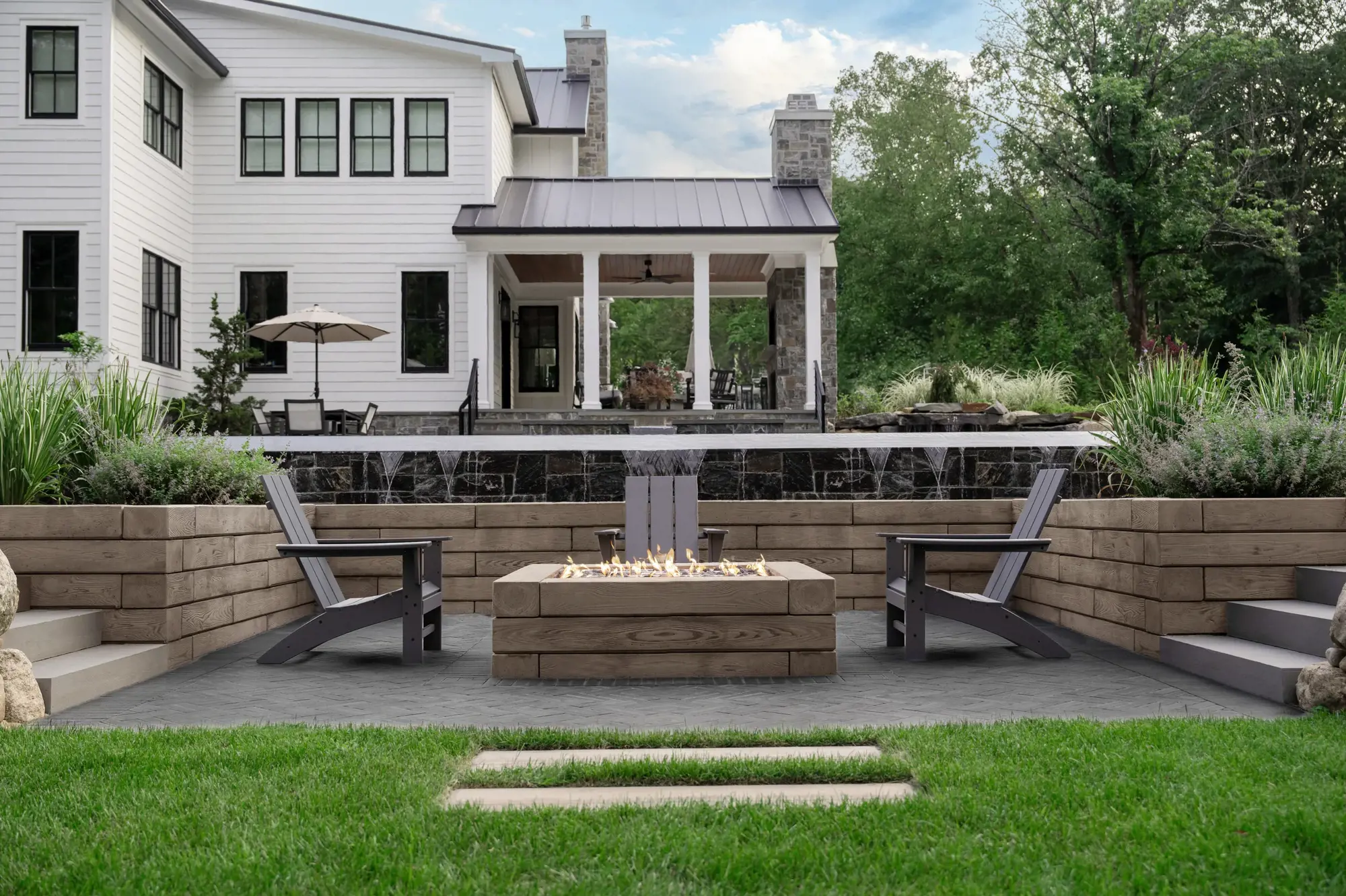 Modern outdoor firepit lounge with Techo-Bloc walls and slabs creating a warm and welcoming backyard setting.