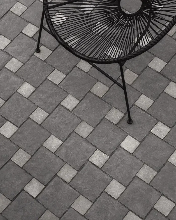 Outdoor dining area with Techo-Bloc Valet and Squadra pavers in gray checkerboard pattern.