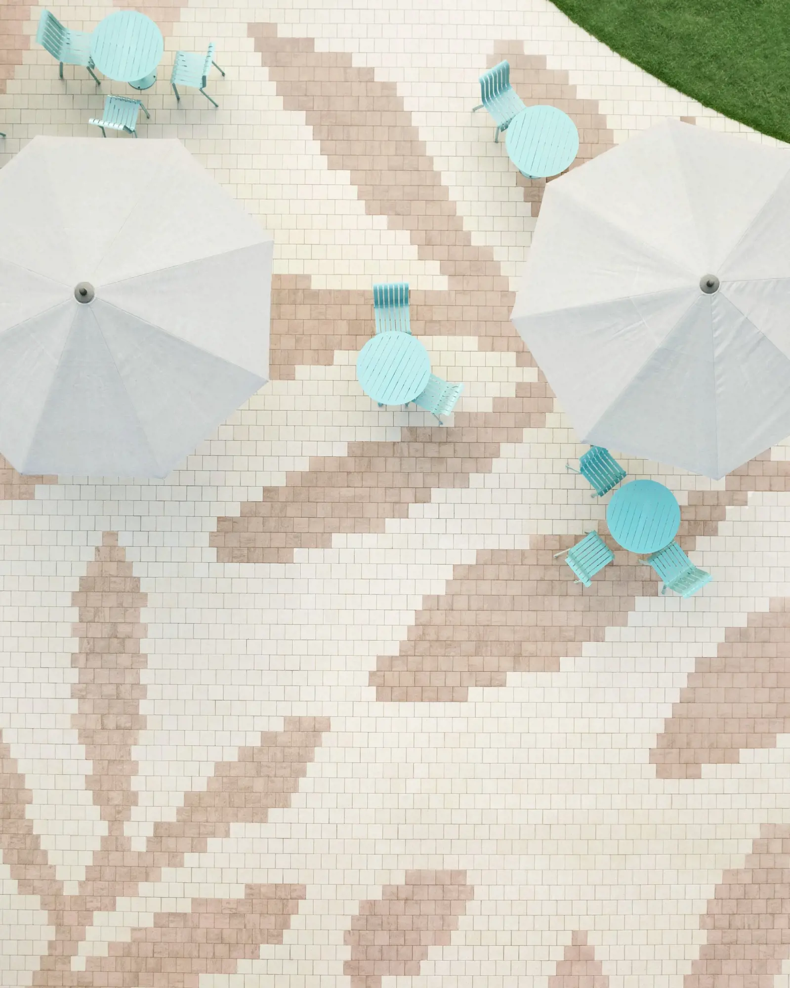 Vue aérienne du centre communautaire en pavés Industria HD² Granitex de Techo-Bloc, motif floral beige et brun avec mobilier extérieur.
