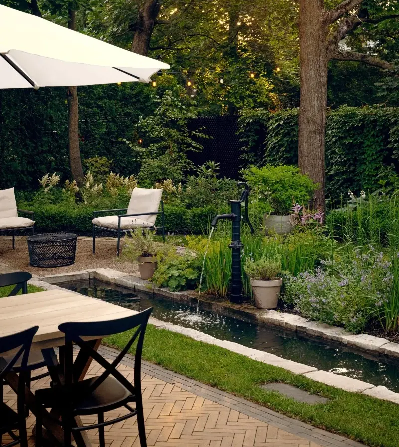 Garden edge detail with a Westmount border in Onyx Black framing herringbone concrete pavers and a linear water feature.