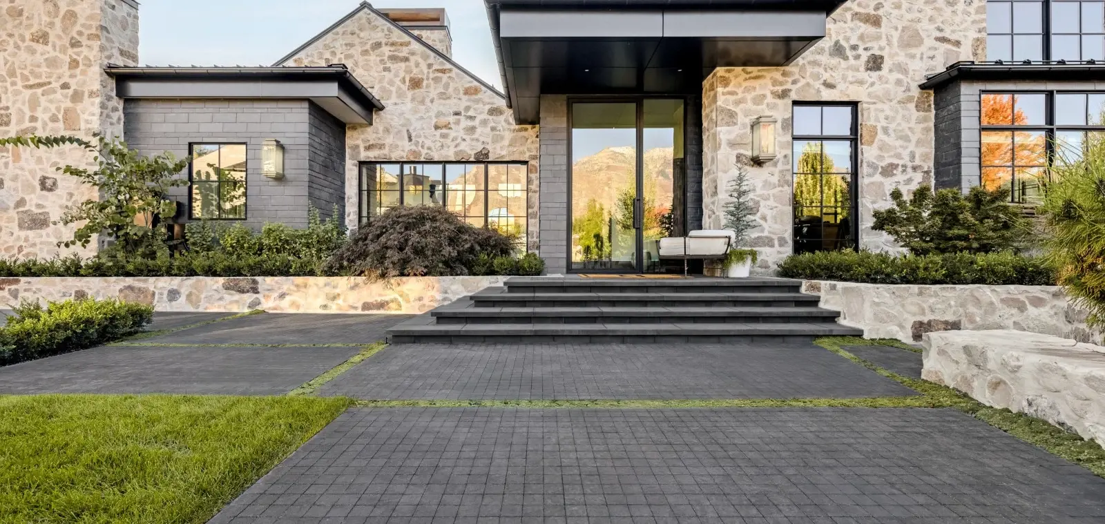 Front entry terrace with Squadra concrete pavers, Westmount pavers for contrast, and central steps leading to the home.