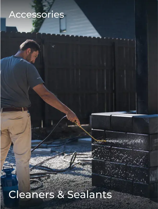 Contractor cleaning a stone pillar with a spray-on outdoor surface cleaner—ideal for maintaining the appearance of vertical hardscape features.