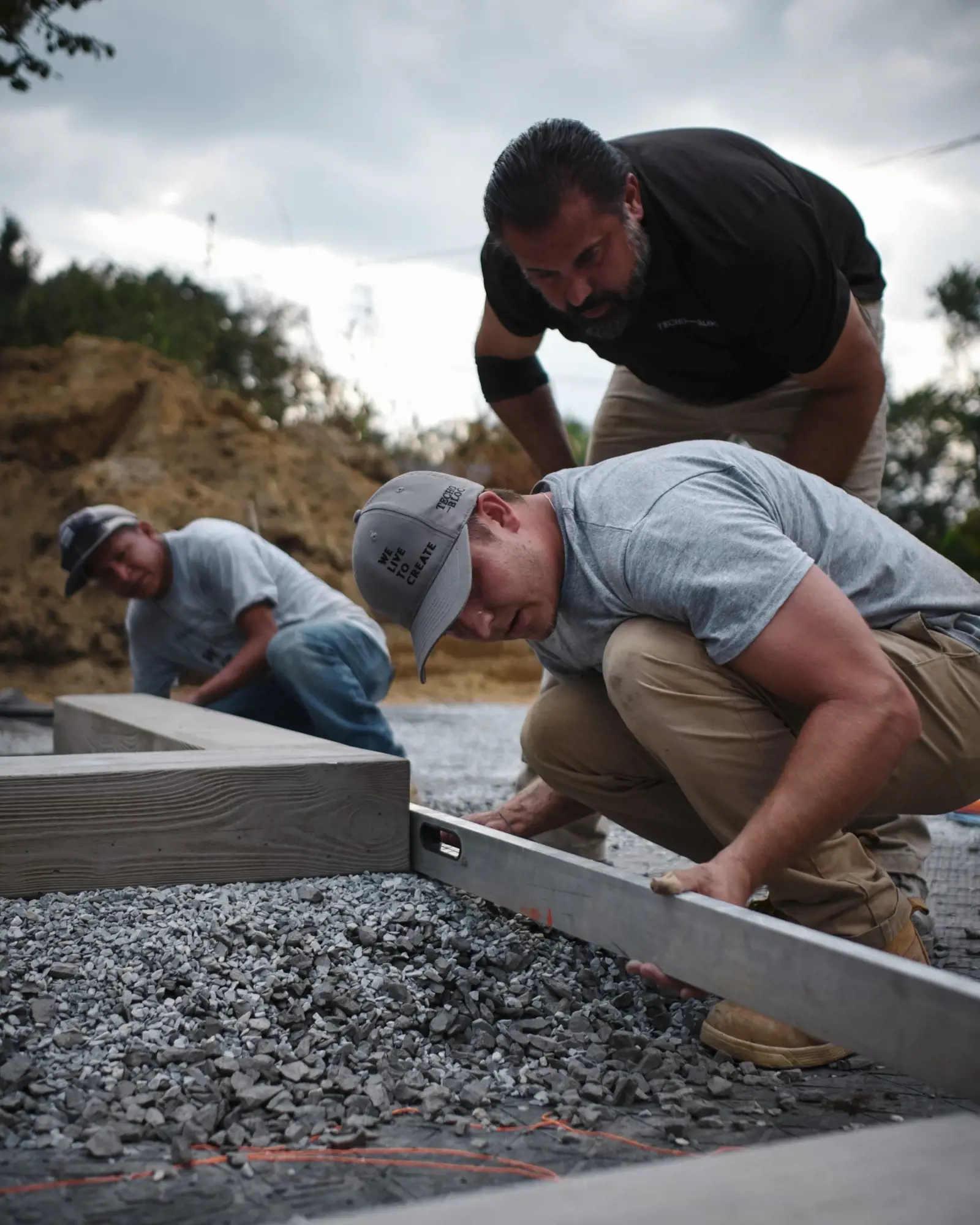 Techo-Bloc contractors working on-site leveling gravel, representing the hands-on support and exclusive benefits offered through the Techo-Pro Program.
