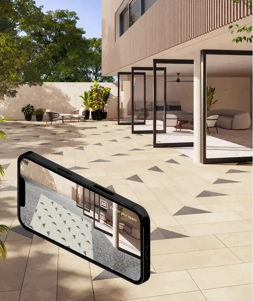 Phone held over a patterned paver patio showing the AR viewer previewing a product in place