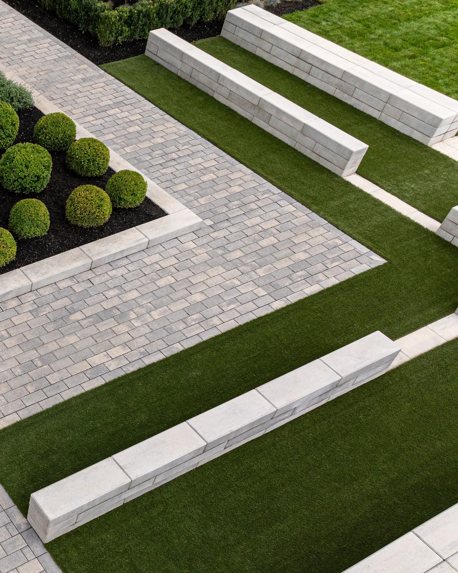 Bancs et murets d’assise du Peace Park réalisés en couronnements Raffinato de Techo-Bloc en nickel grisé.