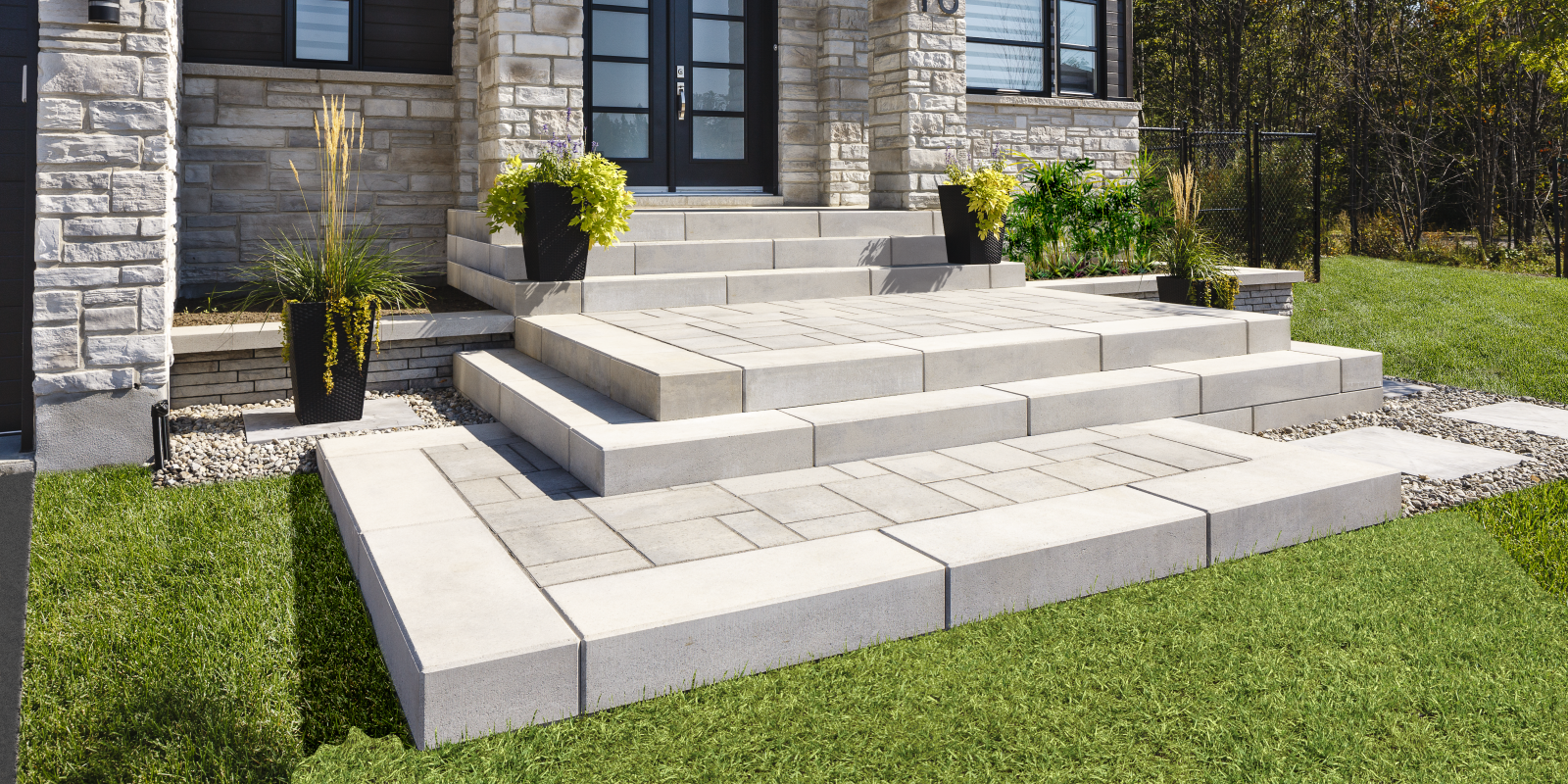 Raffinato steps in light grey with a modern paver front entrance and raised landing at a stone house.