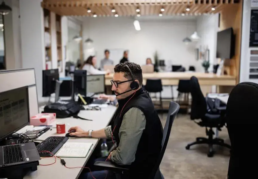 Techo-Bloc Employee sitting at a computer answering design calls.