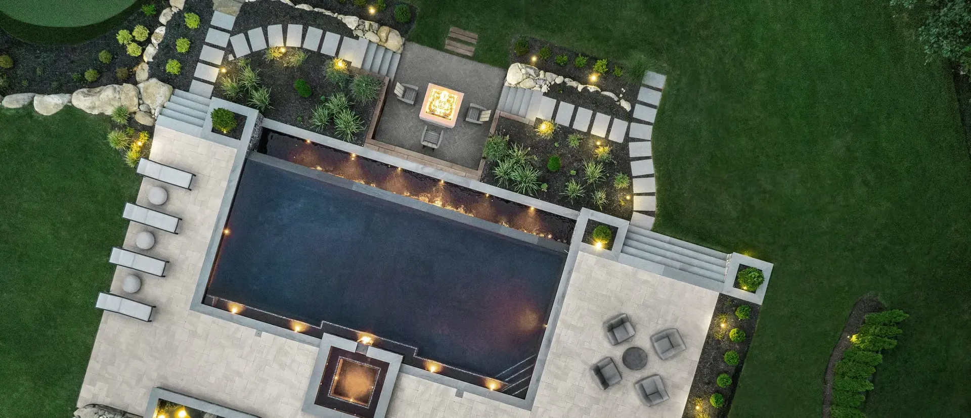 Aerial view of modern pool area with geometric Techo-Bloc pavers and cohesive outdoor zones.