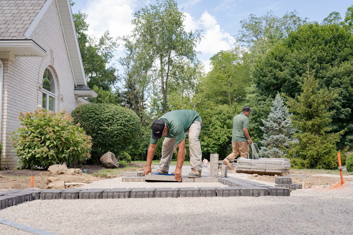 Contractors installing pavers at a hardscaping job. 