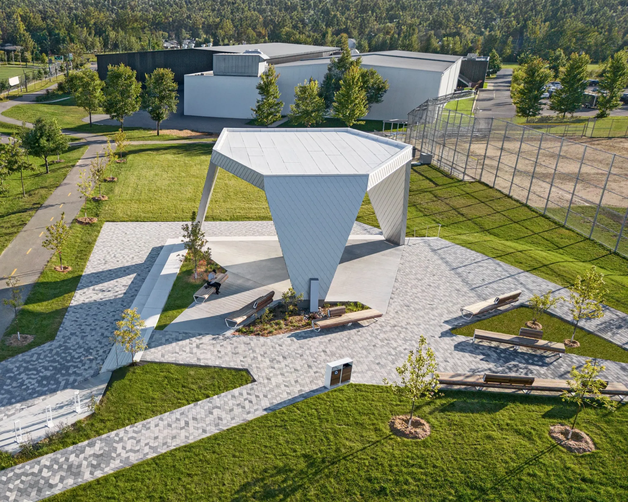 Vue aérienne de la place du parc Philippe-Villeneuve avec pavés Diamond HD² Smooth, bancs et une arche sculpturale moderne.