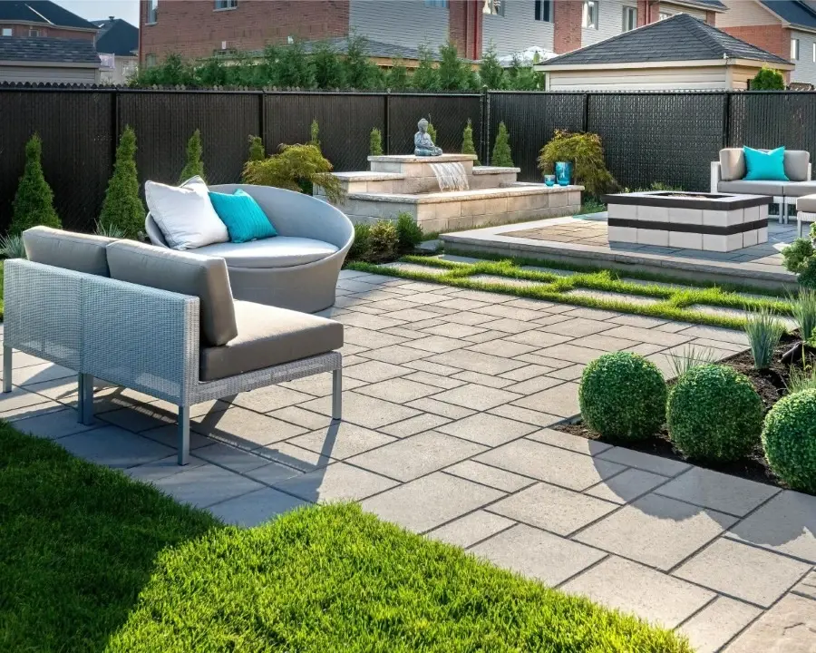 Blu 80 Smooth paver by Techo-Bloc in Greyed Nickel, laid in a modular pattern for a stylish patio with seating and planters.