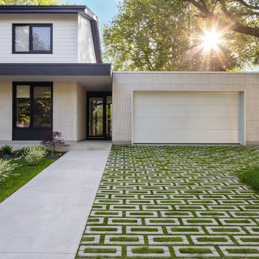 Aquastorm Paver by Techo-Bloc in Natural Grass with geometric grid, creating a green permeable driveway for eco-friendly homes.