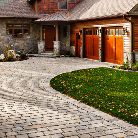 Pure Pavers by Techo-Bloc, large cobblestone pavers arranged in a permeable layout, creating a stylish and functional driveway for residential spaces.