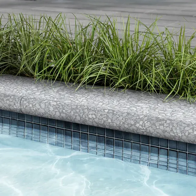 Terrazzo Bullnose by Techo-Bloc, rounded pool cap with a sleek edge, offering a stylish and safe finish for poolside areas in Mineral White.