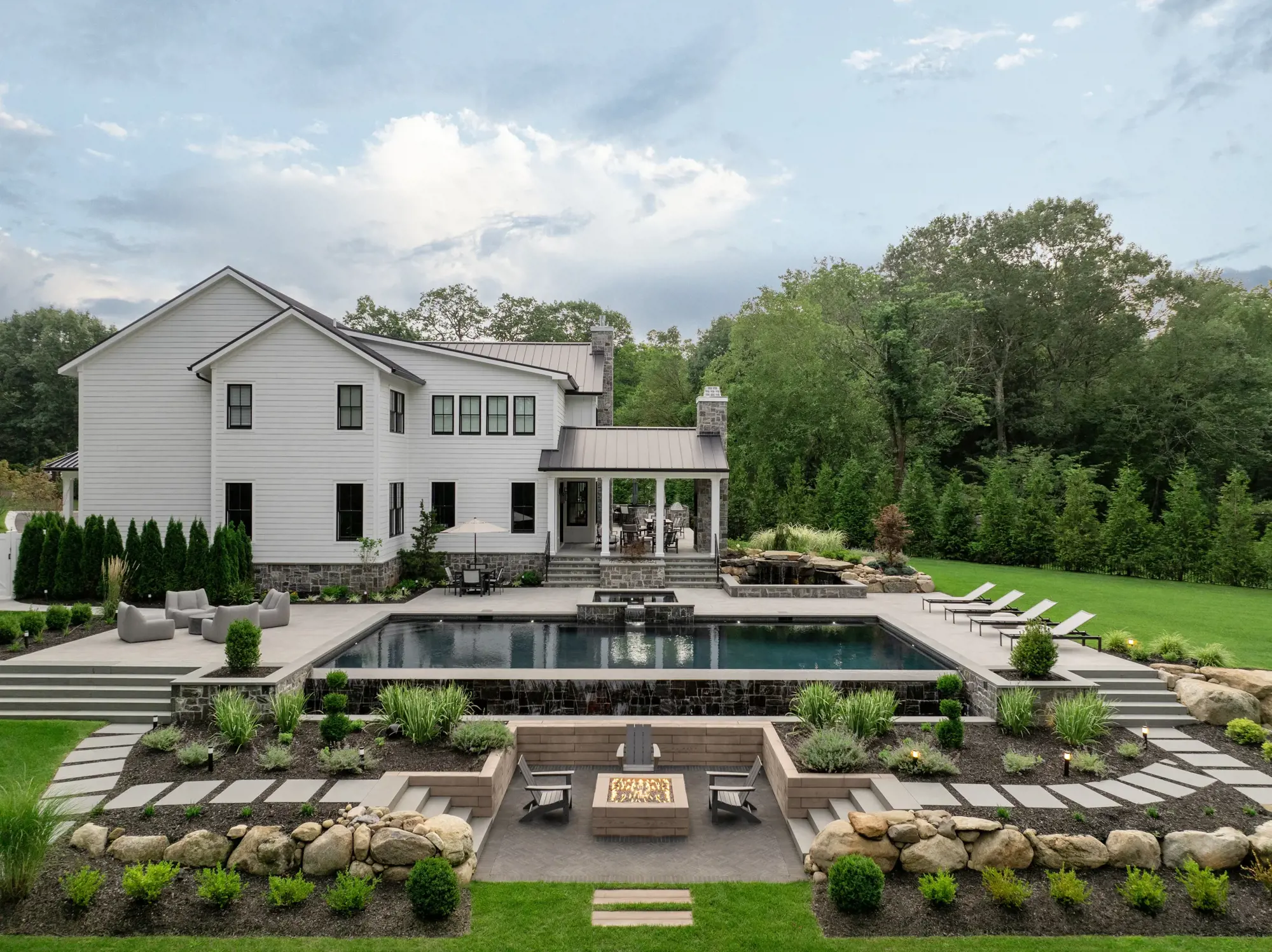  Wide landscape shot showing upgraded backyard with pool, patio spaces, and integrated greenery.