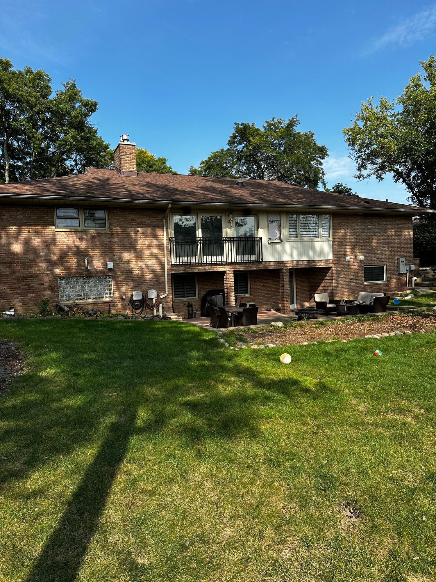 Backyard before renovation showing aged decking, minimal landscaping, and unused outdoor space.