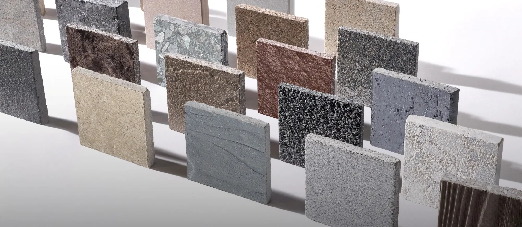 Concrete paver and slab samples in various textures and colors displayed for selection