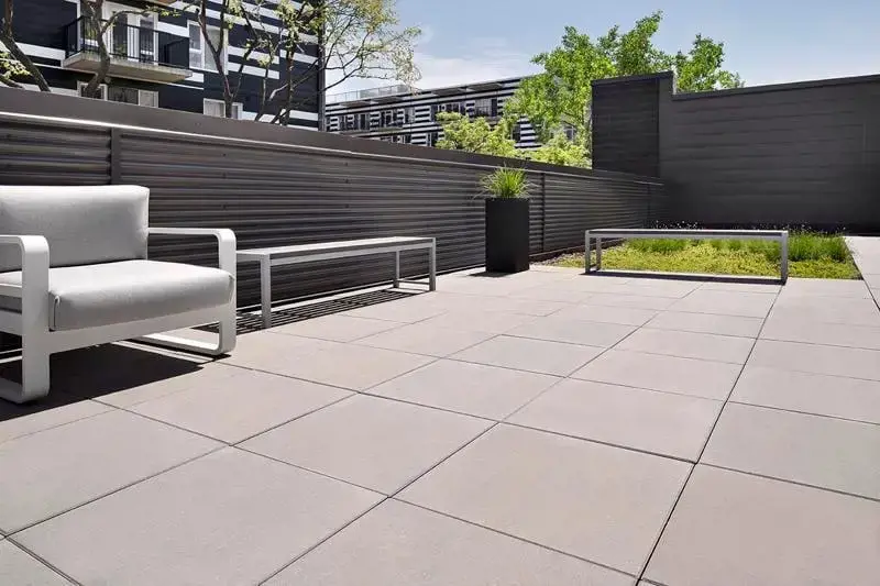 Pedestrian plaza featuring Techo-Bloc large-format commercial slabs with modern seating and tiered retaining walls.