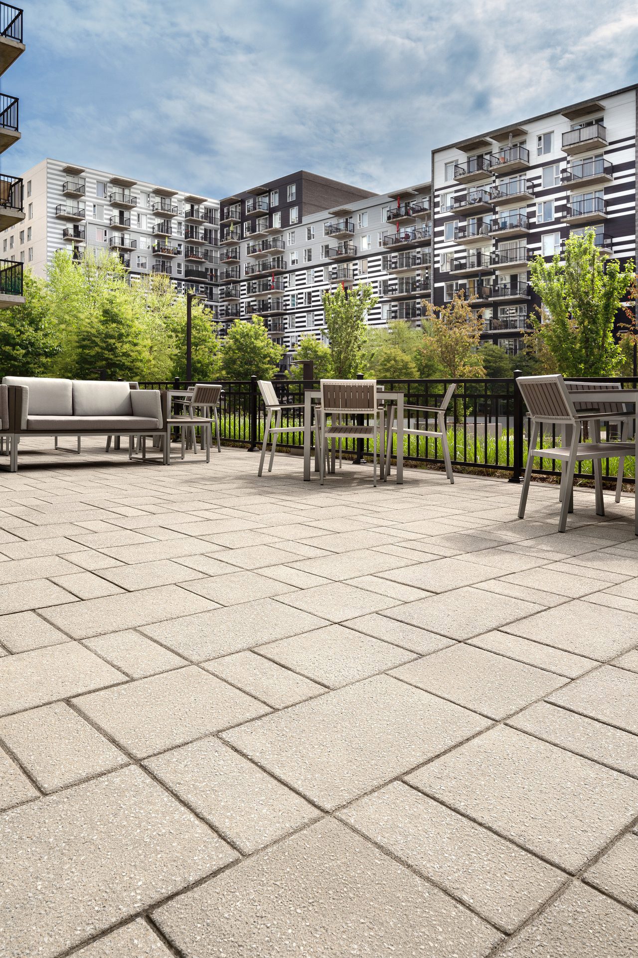 Retirement Home Rooftop with the skyline in the background showing a close up view of Techo-Bloc Industria Granitex Paver in Greyed Nickel.