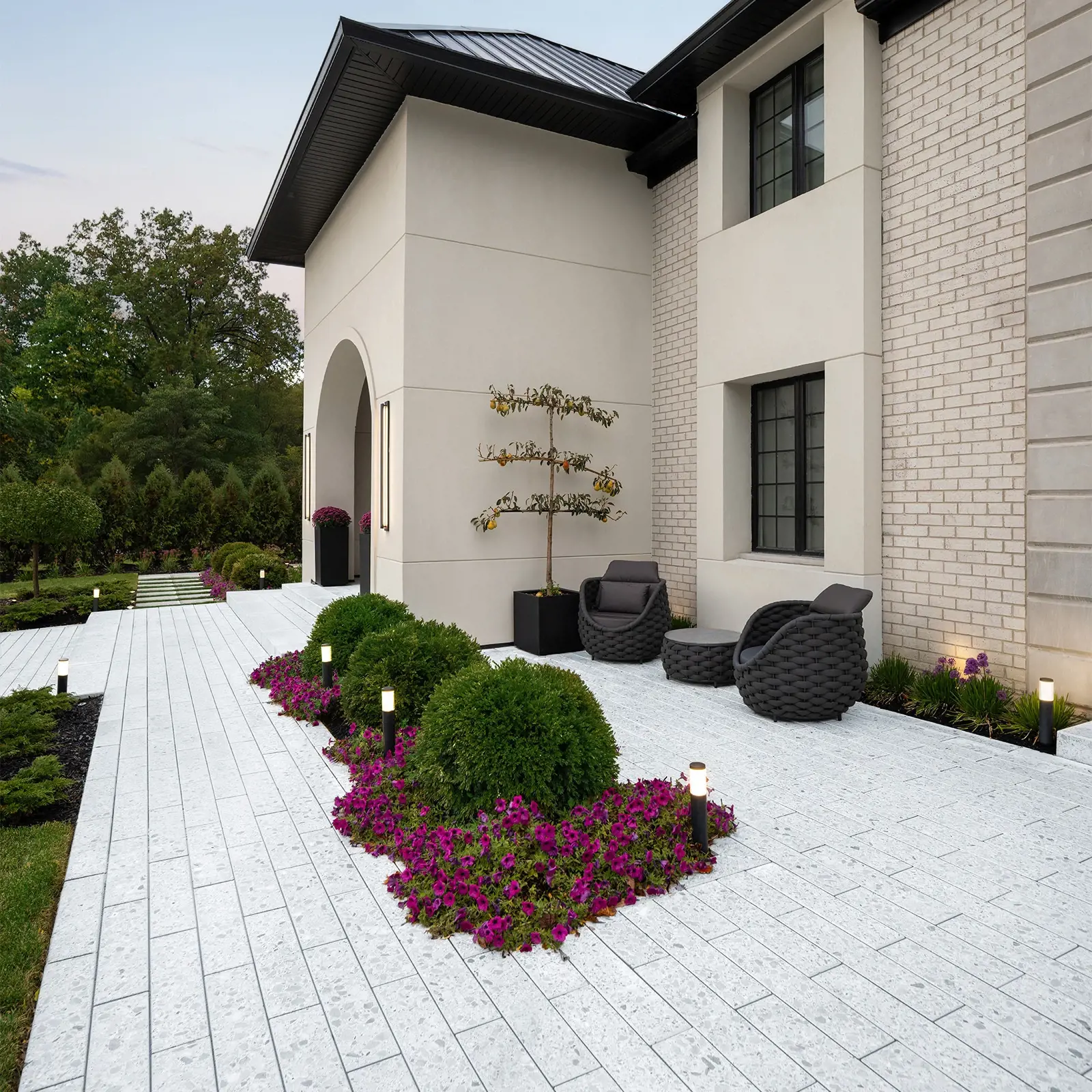 Terrazzo Slab in Mineral White forming a linear walkway along a home frontage with flowering landscape beds