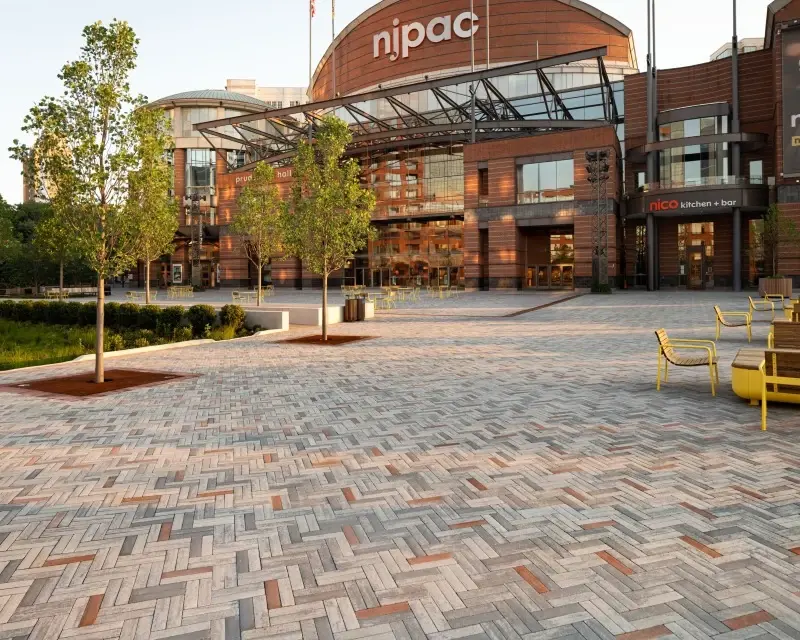 Place publique pavée avec des pavés Westmount de Techo-Bloc disposés en motif linéaire moderne, offrant une surface durable et facile d’entretien pour les espaces urbains contemporains.