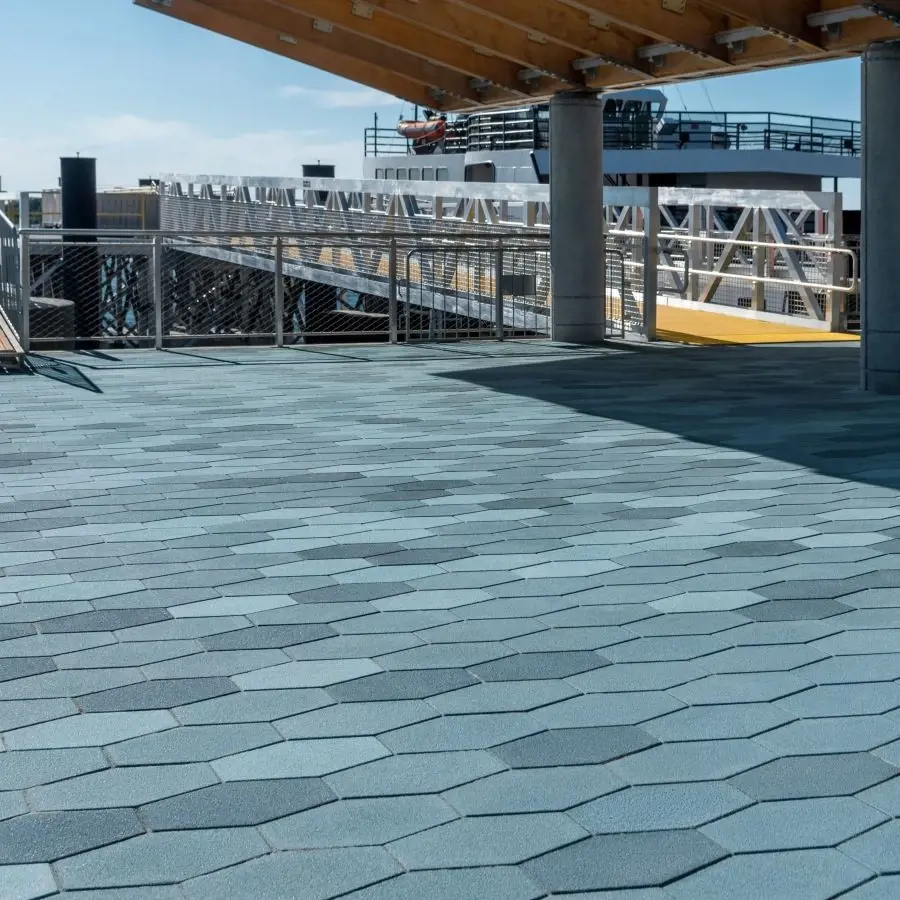 Espace public au bord de l’eau mettant en valeur les pavés Hexa de Techo-Bloc dans une disposition hexagonale saisissante, conçue pour la solidité et l’impact visuel.
