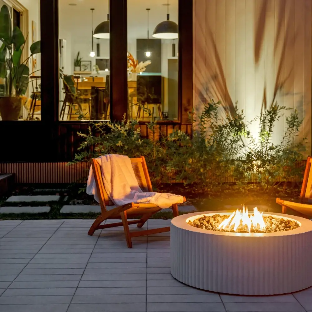 Patio contemporain avec foyer extérieur rond, coin détente et pavés texturés pour recevoir à l’extérieur
