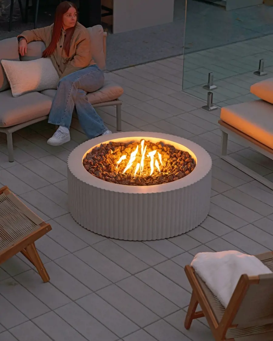 Modern patio scene with a Sculptura fire pit integrated into a seating area, creating warmth and ambiance through subtle sculptural design.