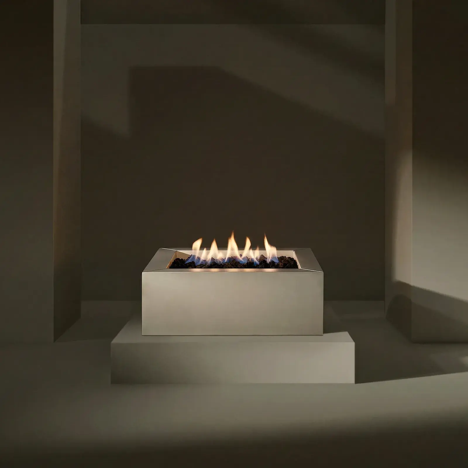 Sculptura Square Firepit in Cool Grey Smooth with a glass wind guard and flames