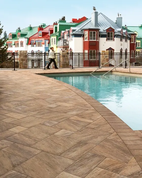 Espace piscine du Fairmont Tremblant aménagé avec Everest HD² Slate en Brun Châtaigne, alliant élégance alpine et durabilité.