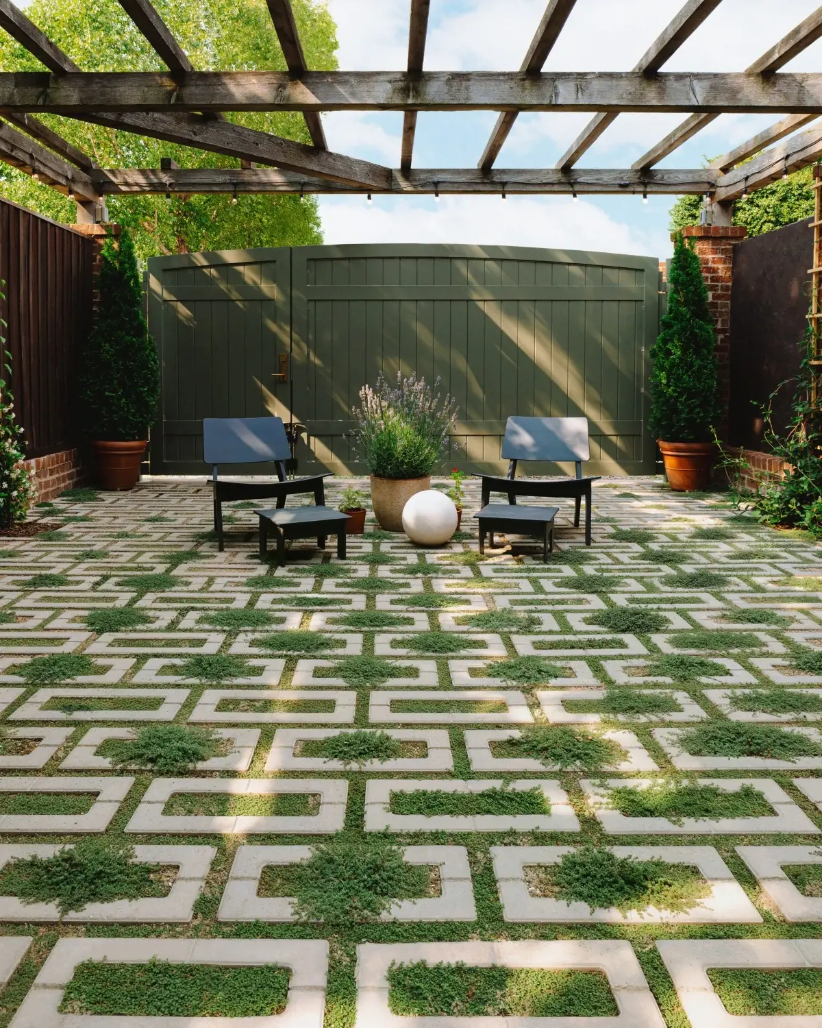 Richmond backyard patio with Techo-Bloc Aquastorm permeable pavers in Shale Grey arranged in a geometric pattern with grass joints and lounge seating.