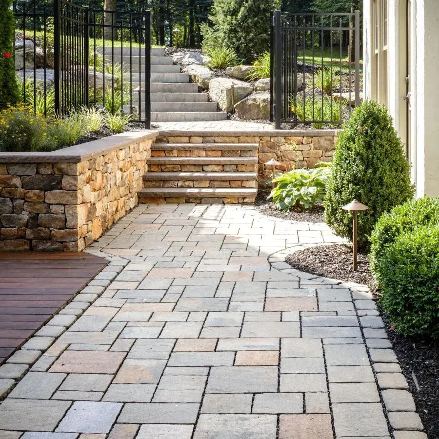 Mista Paver by Techo-Bloc with textured surface, creating a warm driveway blending into lush surroundings.