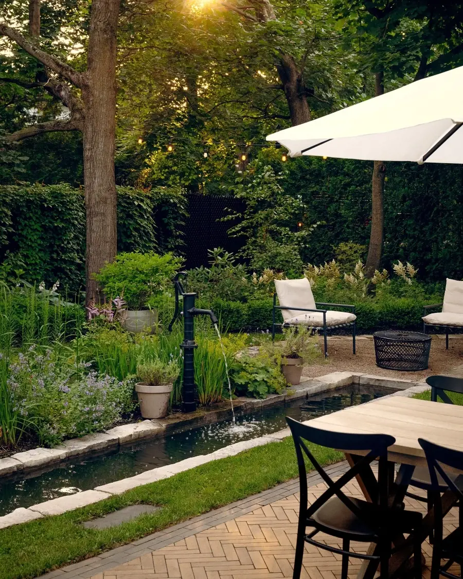 Poolside seating area framed by limestone caps in Onyx Black and Westmount cobblestone style pavers in Chestnut Brown, creating a calm, organic outdoor retreat.