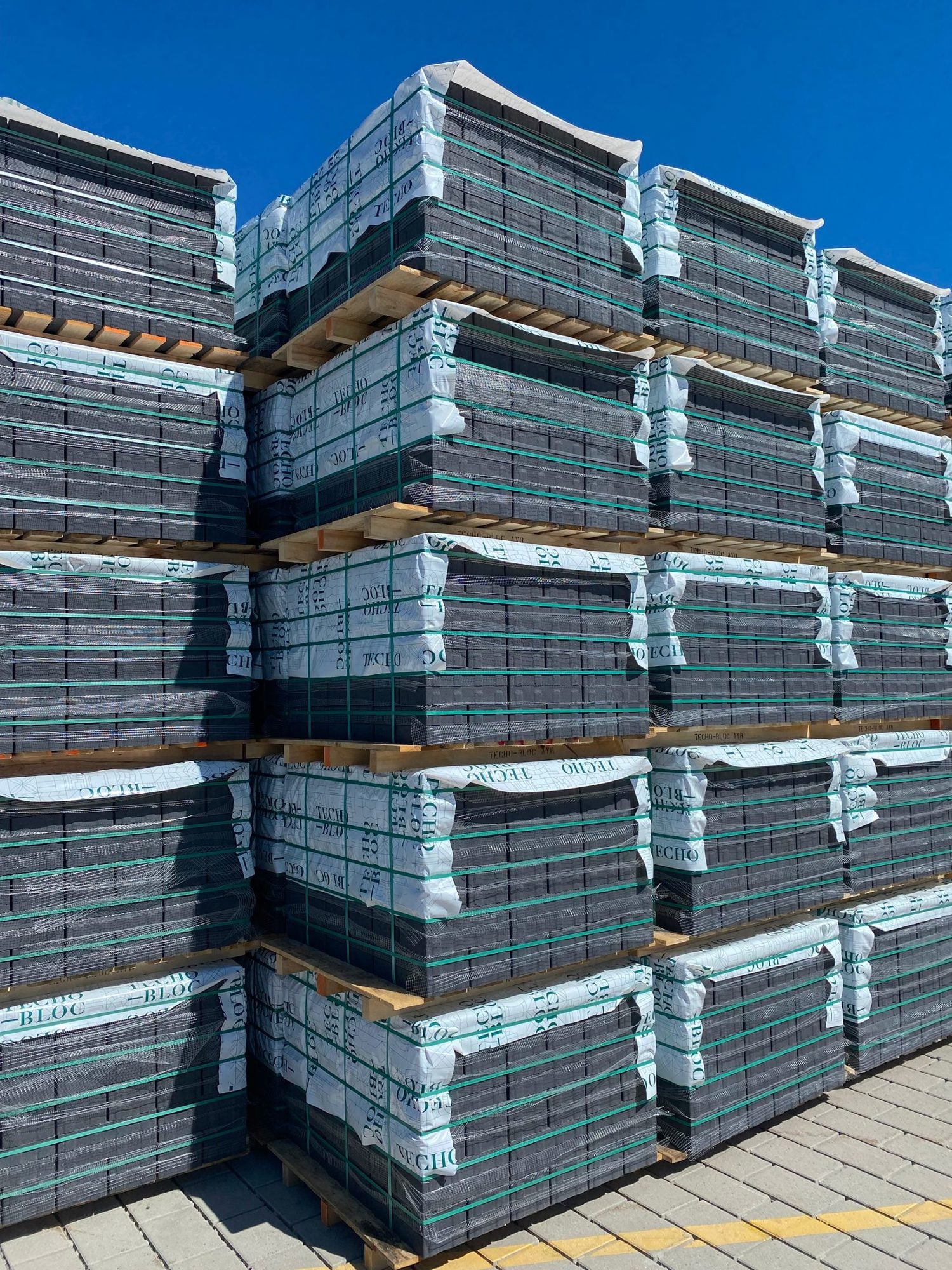 Palletized concrete products secured with a reduced-plastic strapping system after packaging optimization