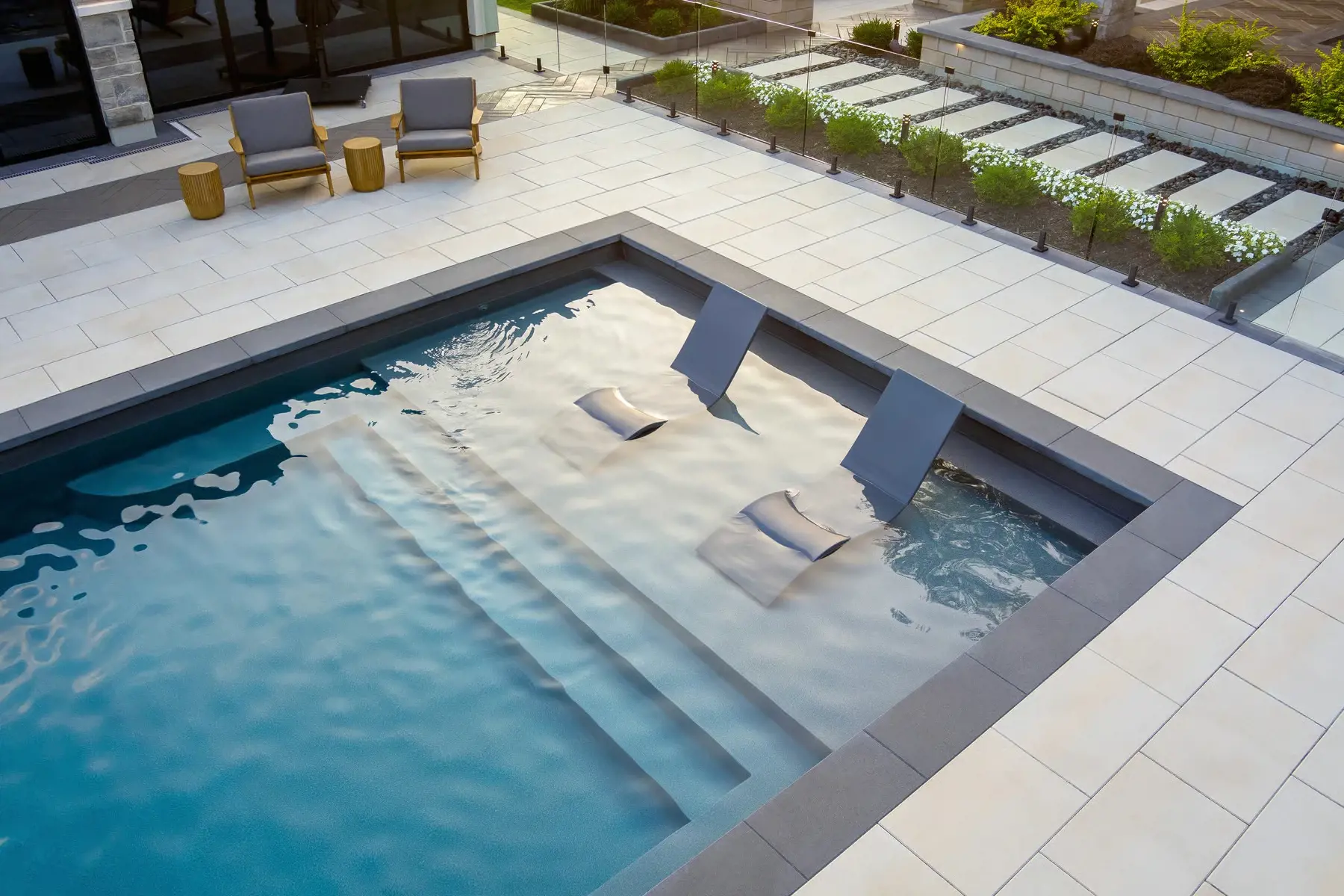 Poolside edging finished with Raffinato Caps in Onyx Black creating a refined modern border around the water.