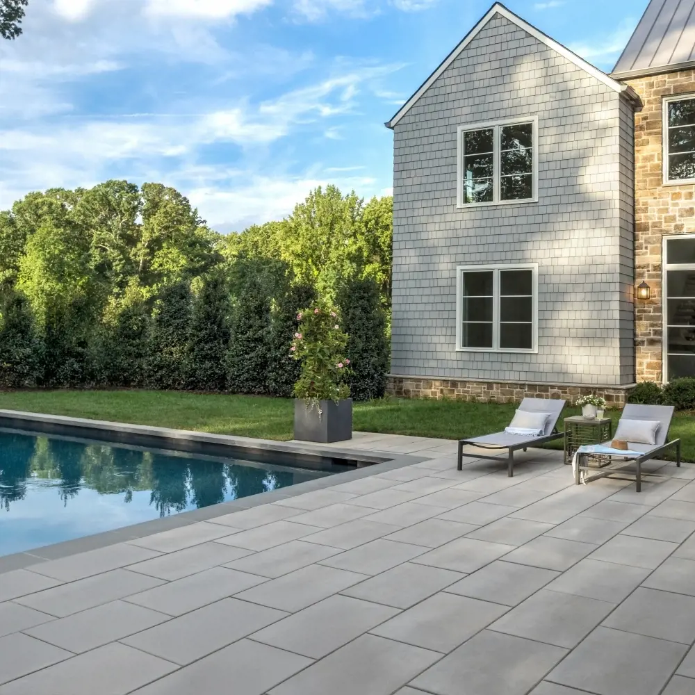 Patio moderne avec grandes dalles, foyer linéaire et aménagement structuré pour un espace extérieur haut de gamme