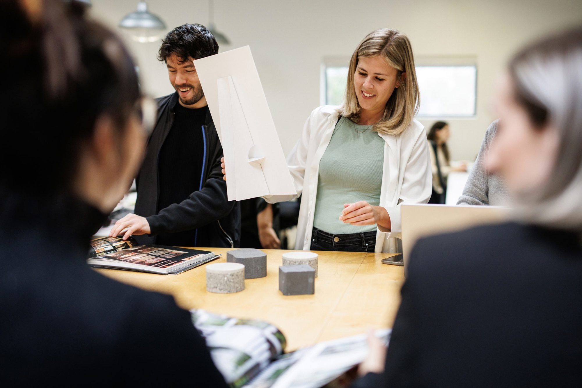 Employés collaborant lors d’une séance de formation pratique, examinant des documents et apprenant ensemble dans un environnement professionnel.