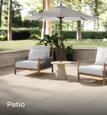 Blu 60 pavers by Techo-Bloc in Beige Cream with smooth texture form a clean, relaxing patio with chairs and umbrella.