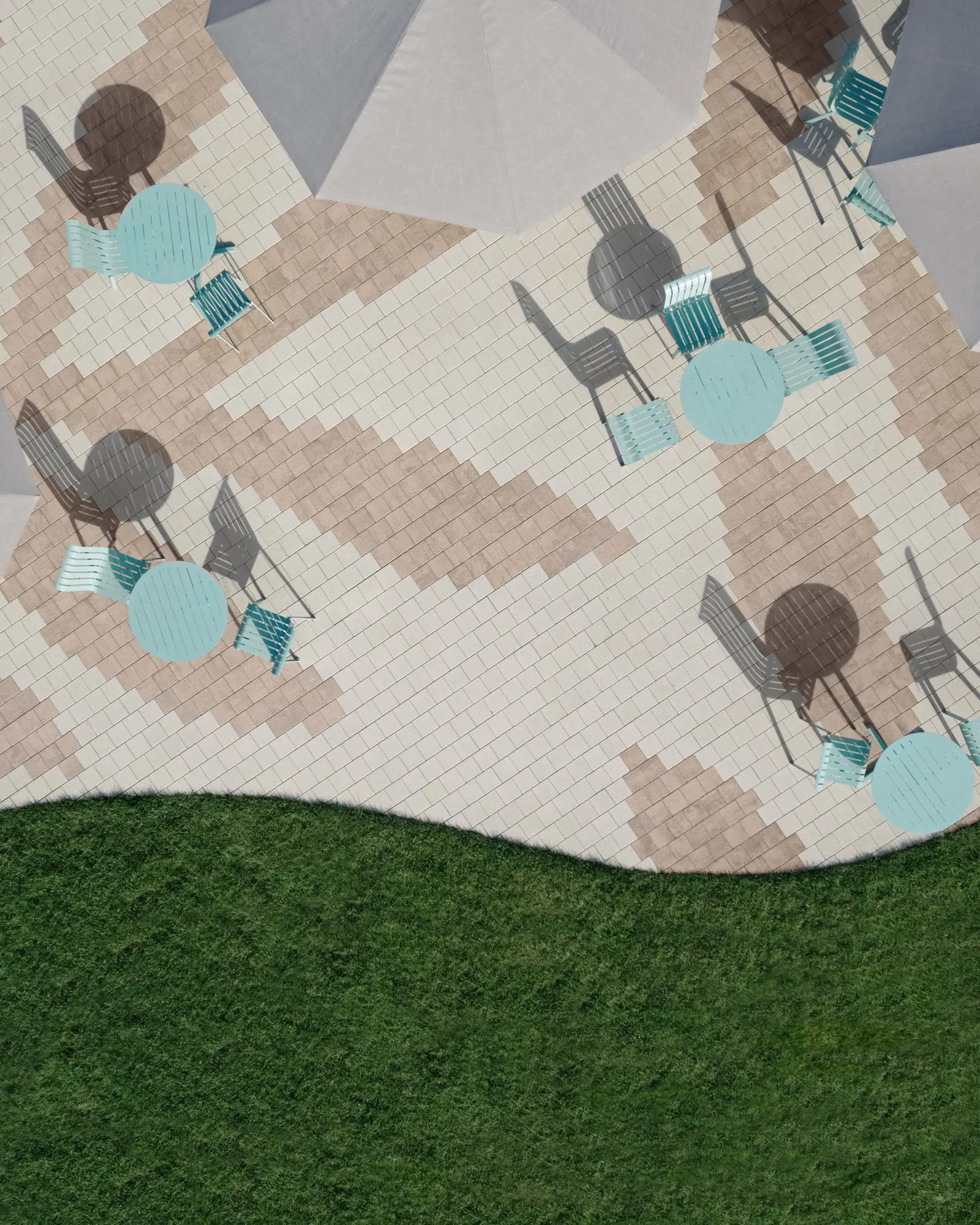 Vue complète aérienne du centre communautaire pavé en Industria HD² Granitex de Techo-Bloc avec motifs organiques beige et brun.