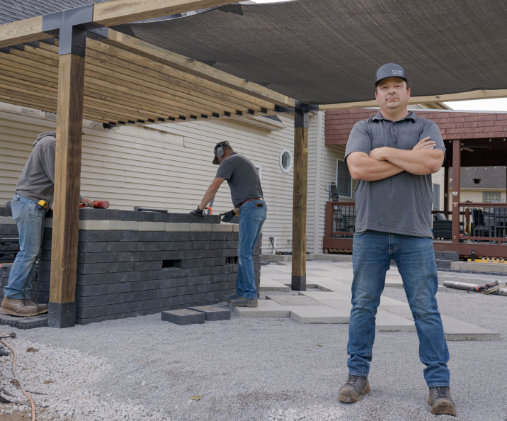 Pavés Squadra par Techo-Bloc en Onyx Black en cours d’installation pour un patio avec pergola et bar intégré.