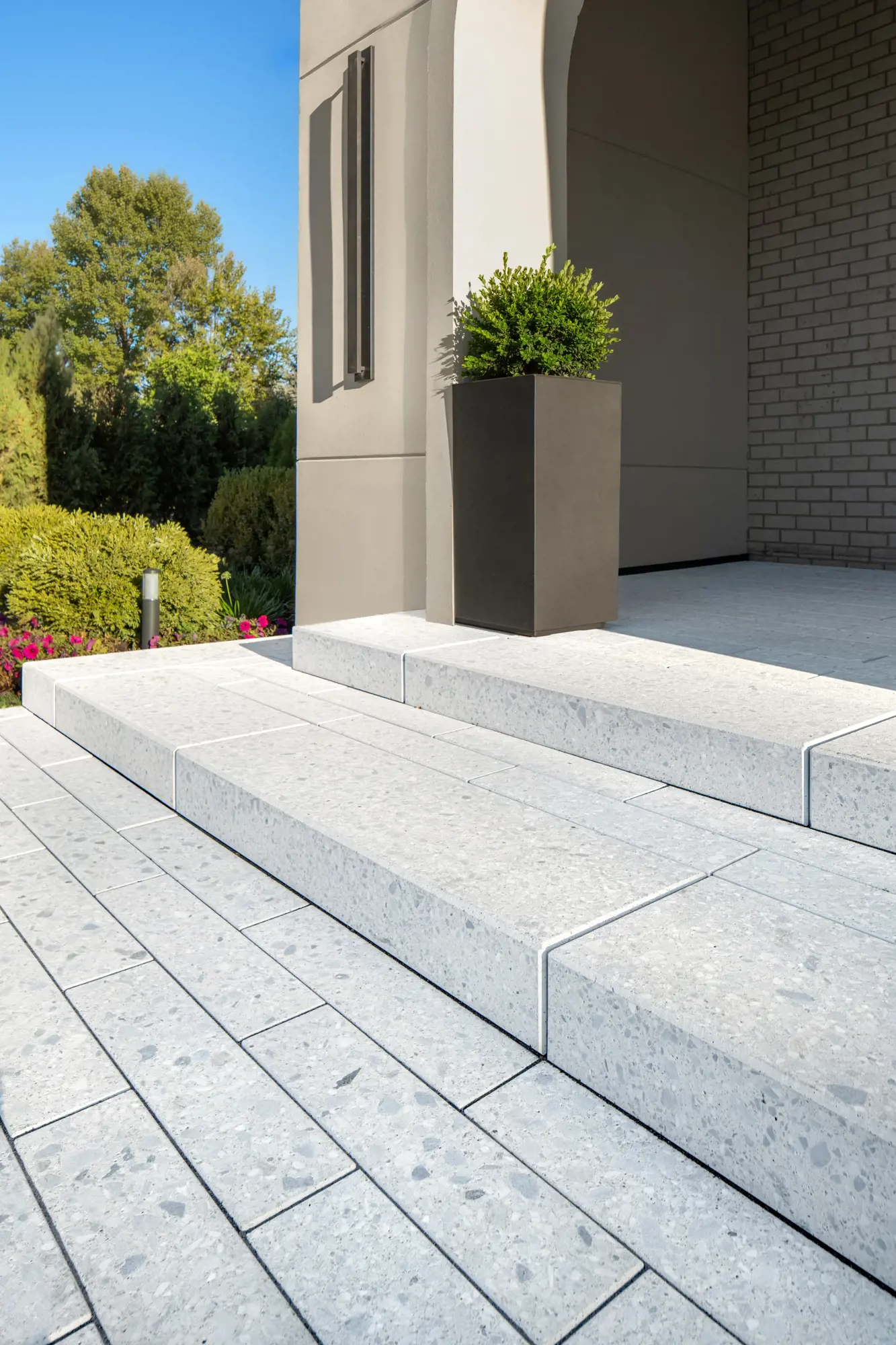 Gros plan sur des marches en Terrazzo à bord texturé près d'une haute jardinière