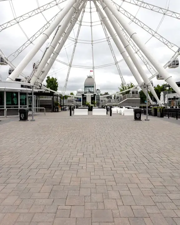 Pavés Blu 60 recouvrant une grande place sous une grande roue dans un site touristique achalandé.