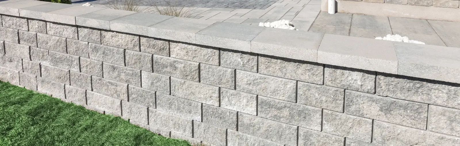 Semma Wall retaining wall with split-face texture in a modern grey outdoor landscape design 