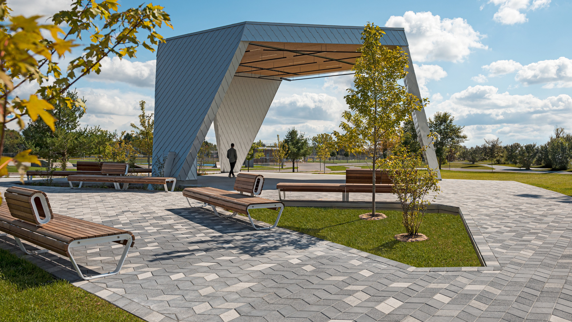 Place du parc Philippe-Villeneuve avec pavés Diamond HD² Smooth de Techo-Bloc en gris et noir sous une arche sculpturale.