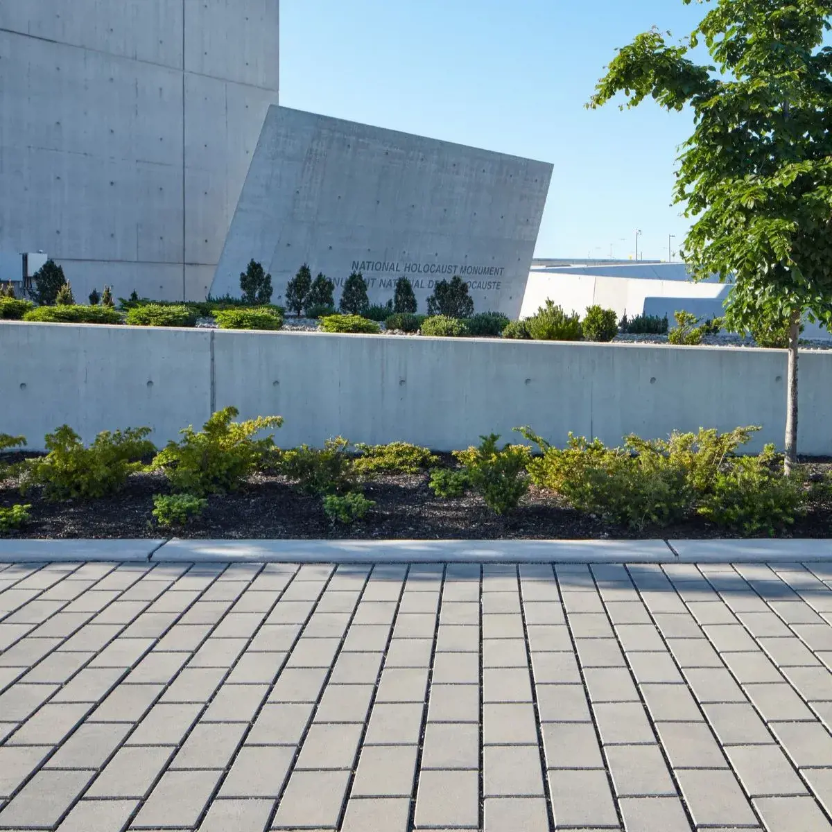 Hydra Paver by Techo-Bloc in Greyed Nickel with linear pattern, offering a sleek permeable driveway that reduces water runoff.